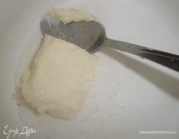Мягкое сливочное масло смешиваем с оставшимся сахаром, растираем до однородности. Добавляем желтки. 