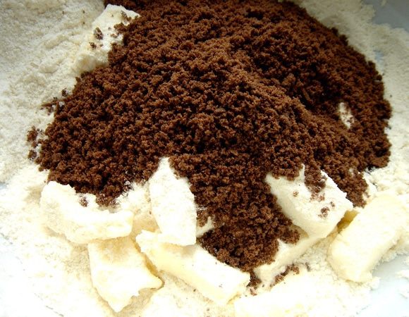 Печенье(у меня шоколадное)измельчить в блендере.Смешать все сухие ингредиенты для песочного коржа и растереть их с маслом в крошку.