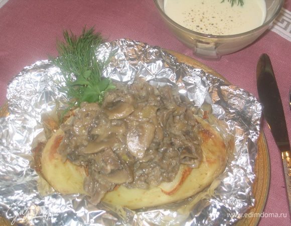 Формируем готовое блюдо: размять вилкой верхушку картофелины, положить во внутрь кусочек сливочного масла и посолить. Грибы выложить горкой сверху и полить сырным соусом, посыпать зеленью, либо добавить зелень в соус. Угощайтесь:-))