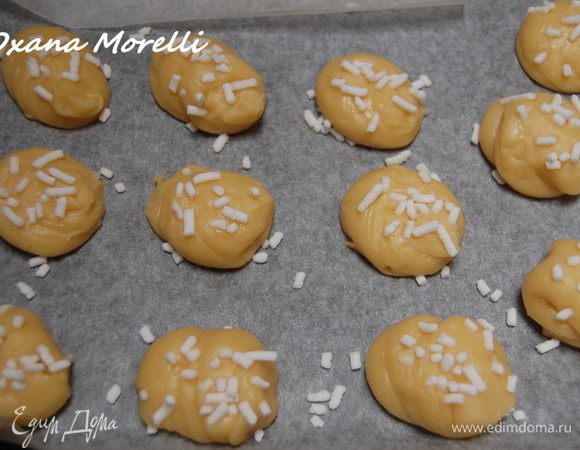Оставшееся тесто выложить в кондитерский мешок и отсадить на противень круглые "туловища" диаметром примерно 4 см. Поверхность присыпать сахарными гранулами.  