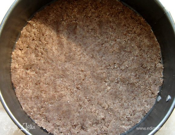 Дно разъёмной формы выстелить пергаментом.Руками распределить песочное тесто по дну.