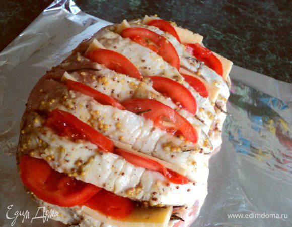 Сыр порезать пластинками, помидор кружочками. Вставить в разрез пластинки сыра и помидоры.