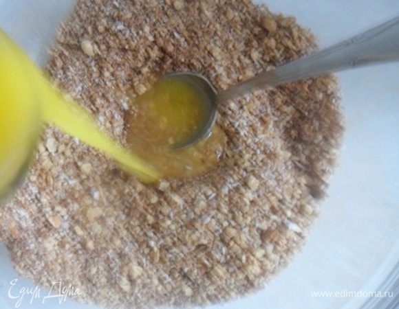 Вливаем в сухую массу растопленное сливочное масло,хорошо перемешиваем ложкой.