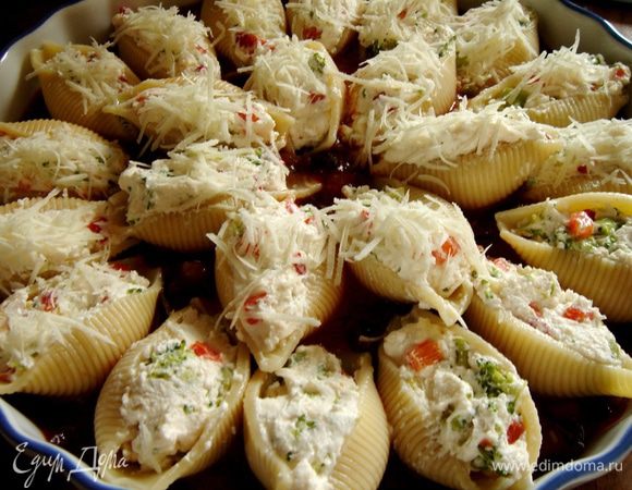 Соус капоната вылить в большое(пасты получается много)жаропрочное блюдо.Конкильони наполнить начинкой и выложить на(в)соус,присыпать оставленным пармезаном,сбрызнуть оливковым маслом и поставить в нагретую до 180*С духовку на 25-30 минут.