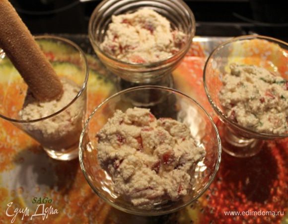 На дно креманок высыпаем половину крошки печенья. Выкладываем половину творожного крема. 