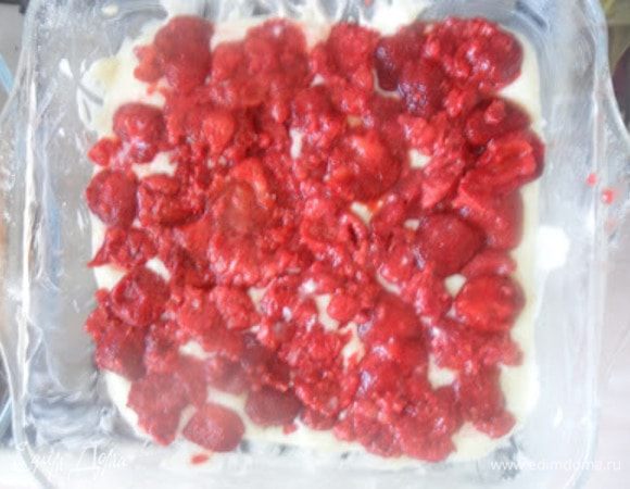 В смазанную маслом форму выложить половину теста,сверху выложить ягоды. Если они замороженные,дать стечь соку и только потом выкладывать на тесто.