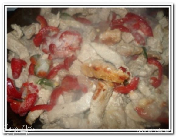 Влить 1/2 стак. воды и тушить на слабом огне до полуготовности. Стручки фасоли нарезать кусками 2-3 см, перец – кольцами, помидоры – ломтиками. В мясо добавить фасоль, перец, чеснок, пропущенный через пресс, тушить 7-10 минут.