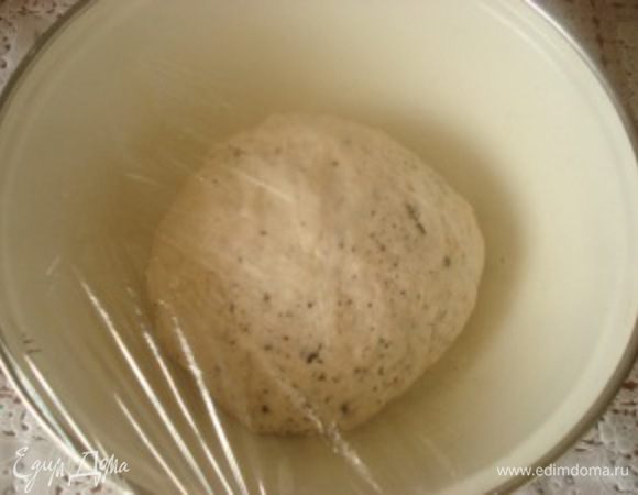 Чашку смазать оливковым маслом, сформировать из теста шар, положить в чашку. накрыть пленкой и поставить в теплое место на 40 минут, чтобы тесто увеличилось в объеме в два раза.