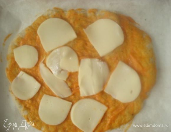 Провести такие же процедуры и со вторым кусочком теста. Подготовленную лепешку из духовки также смазать соусом. Затем выложить сыр сулугуни для пиццы, порезанный ломтиками, затем выложить морепродукты, ошпаренные кипятком и обсушенные, и нарезанную кусочками малосоленную семгу. 