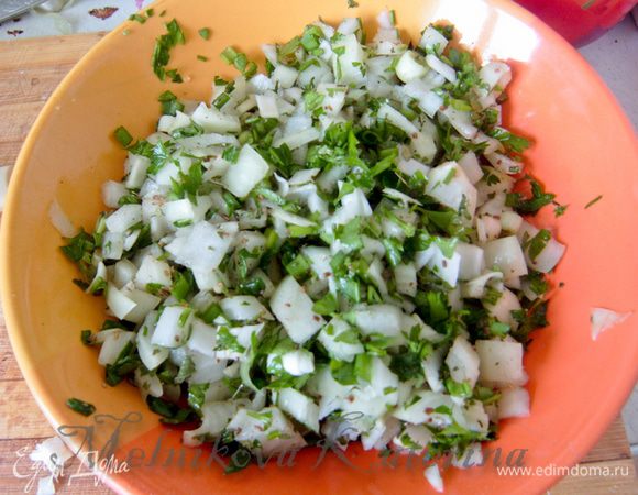 Тем временем подготовить начинку. Для этого лук репчатый мелко нарезать. Также мелко нарезать всю зелень. Добавить соль и зиру, перемешать.