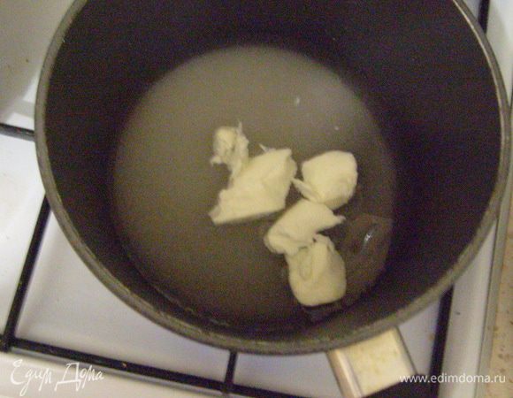 В это же время готовим карамель. Сахар, воду и сливочное масло добавляем в кастрюлю с толстым дном.