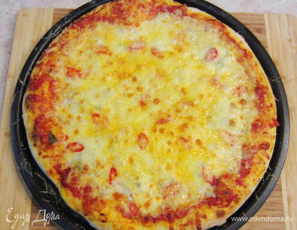 Разогрейте духовку до максимальной температуры. Поставьте в самый низ решетку. Когда печь прогреется - поставьте на решетку пиццу. Выпекайте 7-10 минут (у меня - около 12 минут). За 3 минуты до конца запекания, посыпьте пиццу Пармезаном. Когда сыр подрумянится и снизу пиццы появится аппетитная корочка - снимайте пиццу с огня. Выложите пиццу на блюдо и полейте слегка оливковым маслом. Поперчите пиццу и положите свежие листья базилика.