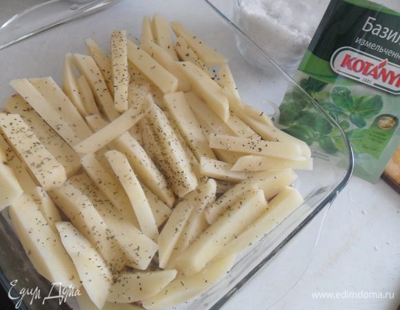 Тем временем почистить и нарезать соломкой картофель и выложить поверх мяса. Посолить,присыпать сушеным базиликом.