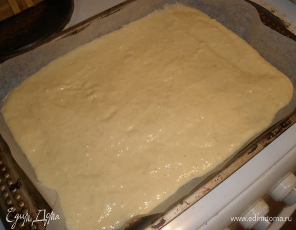 Противень застелить пекарской бумагой, выложить тесто и разровнять.