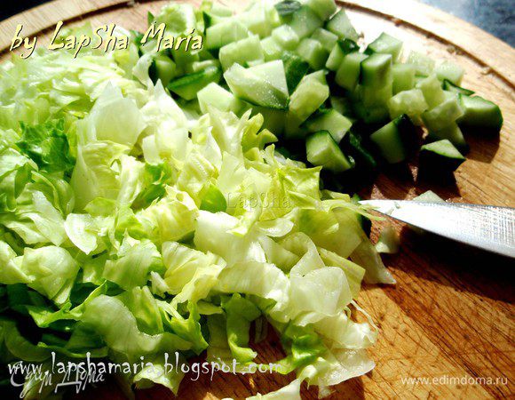 Огурец нарежем на кубики, а салат айсберг довольно мелко нашинкуем, по возможности тоже на квадратики.
