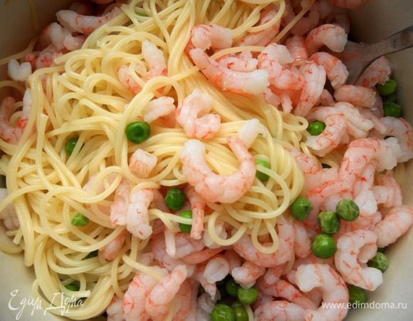 Креветки предварительно разморозить в холодильнике, или на минуту опустить в теплую воду. Спагетти отварить до состояния al-dente (или даже еще на минуту меньше), откинуть на дуршлаг, воду слить. В сковороде разогреть немного оливкового масла, обжарить измельченный чеснок, несколько минут, не допуская потемнения. Присоединить горошек (не размораживая), готовить пару минут, выключить огонь. Соединить пасту, горошек и креветки.