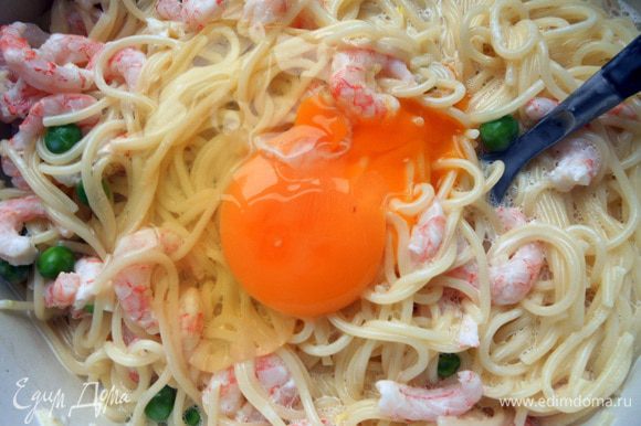 Добавить яйца (по одному, энергично размешивая), соль и перец. На самом деле можно сначала хорошо соединить сыр, горошек, креветки, яйца и специи, а потом уже присоединить спагетти - будет удобнее.
