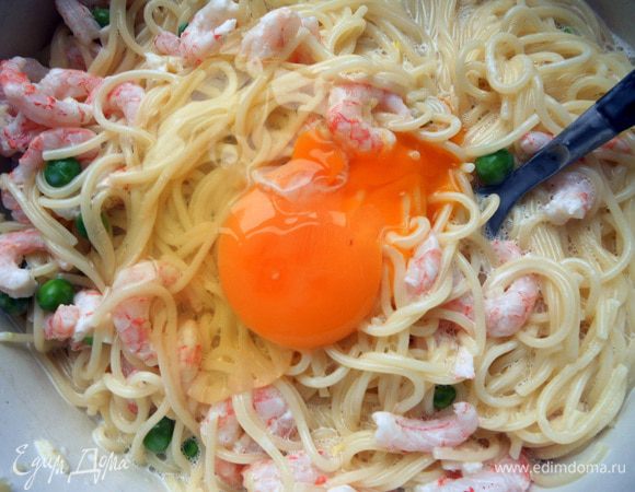 Добавить яйца (по одному, энергично размешивая), соль и перец. На самом деле можно сначала хорошо соединить сыр, горошек, креветки, яйца и специи, а потом уже присоединить спагетти - будет удобнее.