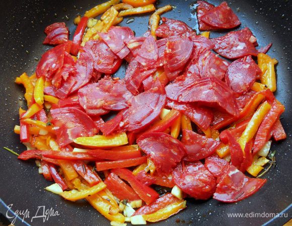 Присоединить колбасу и обжаривать еще с минуту.