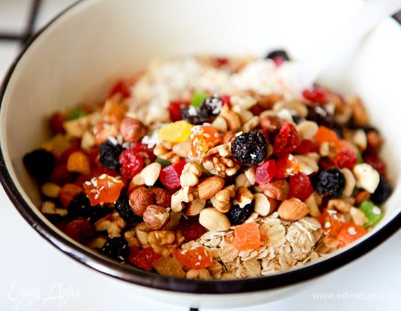 В масляную смесь добавить сухофрукты, кунжут, кокосовую стружку, орехи и овсяные хлопья.