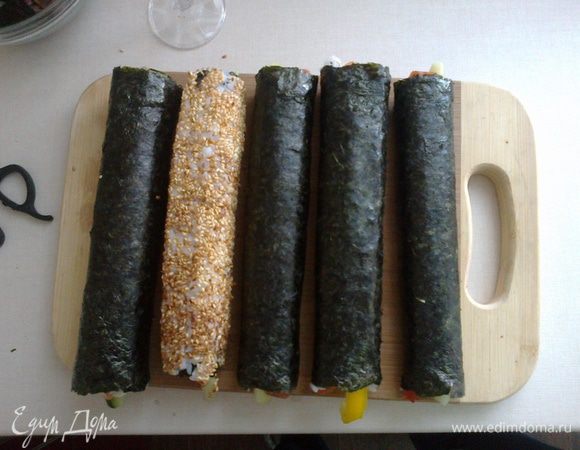 На коврик для суши кладем нори,шершавой стороной вверх,на половину нори выкладываем рис(лучше предварительно смочить руки водой).Кладем начинку в такой комбинации, какая вам по душе (рыба-сыр-оурец, омлет-палочки с мясом краба-огурец).Сворачиваем роллы