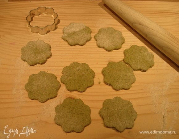 Доску посыпаем мукой, раскатываем тесто и вырезаем печенье с помощью формочек.