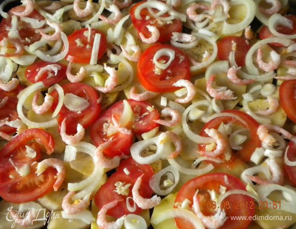 Выложить сверху очишенные креветки.