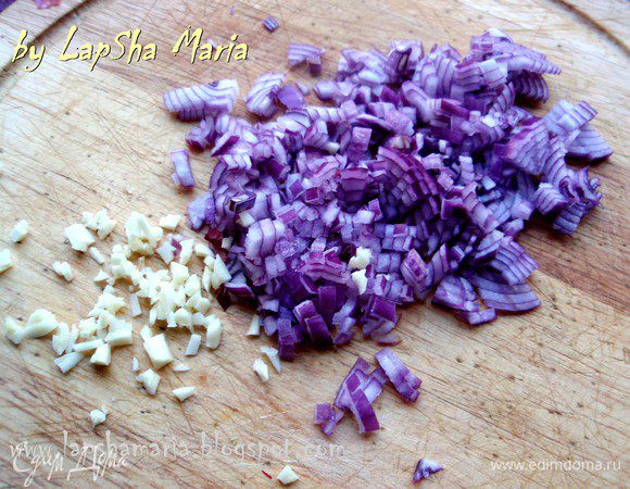 А пока приготовим соус. Для этого мелко нашинкуем лук и чеснок. И обжарим их на большом количестве оливкового масла до прозрачности лука.