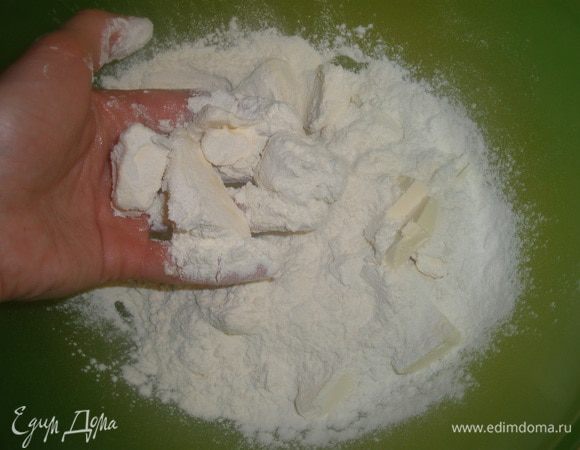 Муку просеять. Добавить охлажденное масло, нарезанное на маленькие кусочки, желток, соль и сахар. Ввести 1 ст ложку очень холодной воды и замесить крутое песочное тесто. Скатать в шар. Если оно не скатывается капнуть еще воды, но лучше не торопиться, а как следует его вымесить руками. Тесто отправить в холодильник на 15 минут. 