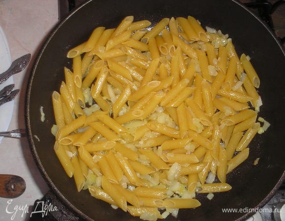 Добавляем сырую пасту и прожариваем несколько минут, чтобы паста впитала масло.