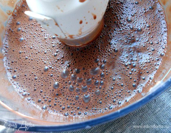 Добавить шоколадные сливки и еще немного взбить (только чтобы соединились компоненты). Вернуть массу в кастрюлю/миску и поставить на водяную баню. Готовить на небольшом огне, постоянно помешивая и не давая закипеть, минут 10 или чуть больше - крем должен немного увариться, загустеть.  Если начнет закипать - тут же снять с огня и влить пару ложек холодного молока/сливок, размешать. После чего вернуть на водяную баню. Снять с огня, поставить миску в холодную воду, продолжая помешивать крем, пока не остынет. 