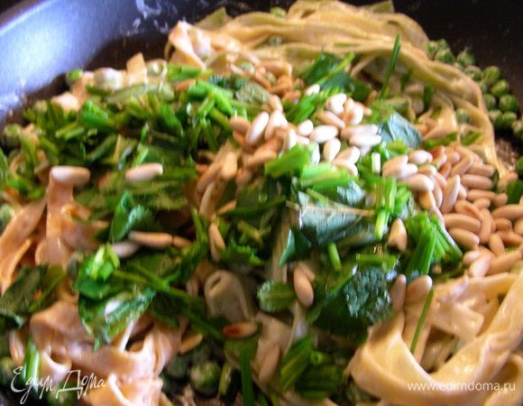 Добавляем в пасту базилик и мяту, аккуратно их вмешиваем. Слишком усердно и много перемешивать не надо, только слегка. Затем добавляем шнитт-лук и кедровые орешки. Прогреваем на небольшом огне несколько минут.