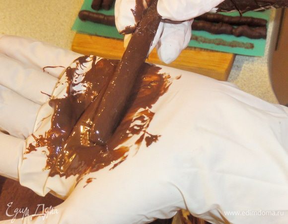 Растопите шоколад. Нанесите небольшую порцию на руку. Обмажьте каждую палочку в шоколаде