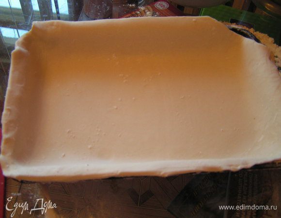 большую раскатать по размеру формы(у меня прямоугольная 22-30-5 см) и выложить в нее сделав бортики(лишнее обрезать ножницами)