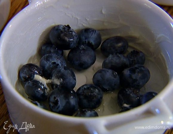 Небольшие керамические формочки смазать оставшимся сливочным маслом, насыпать в каждую понемногу голубики (часть ягод оставить) и влить по 1/4 ч. ложки лимонного сока.