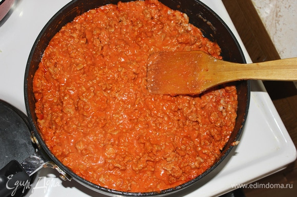 Добавить томатную пасту и немного сливочного масла. Перемешать. Затем влить в баночку из под томатной пасты воду и добавить ее к фаршу.
