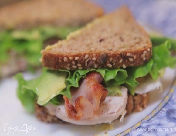 Смазать оба куска хлеба небольшим количеством майонеза. На один выложить куриное мясо, авокадо, бекон и листья салата, смазать майонезом и накрыть вторым куском хлеба. Плотно сжать бутерброд руками.