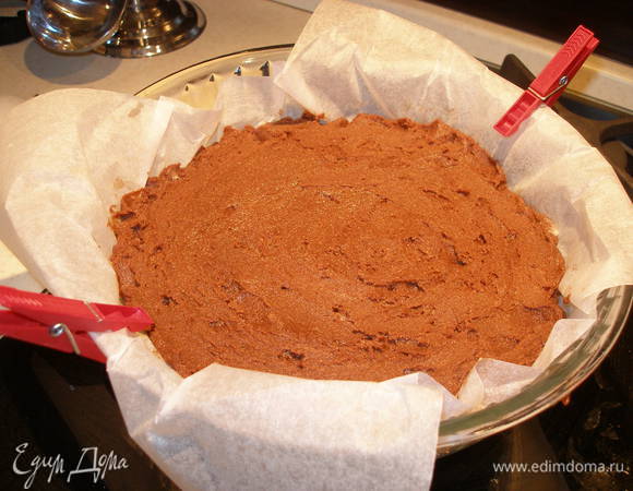 От теста отделить небольшую часть (примерно на 1/2 - 1 стакан) и поместить в холодильник. Оставшееся тесто (это будет нижний слой) выложить в застеленную пергаментом форму. Разровнять. Поставить в холодильник на 30 минут. 