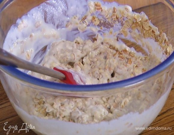 Добавить хлопья с кефиром, муку, изюм, разрыхлитель и все вымешать.