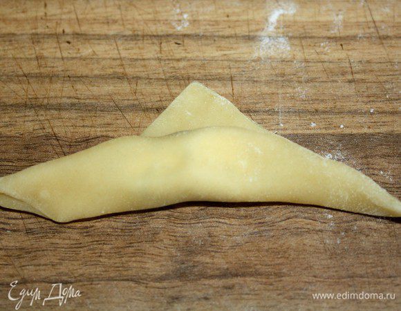 Нижнюю треть треугольника завернуть на верх,оставив маленький "гребешок"сверху.