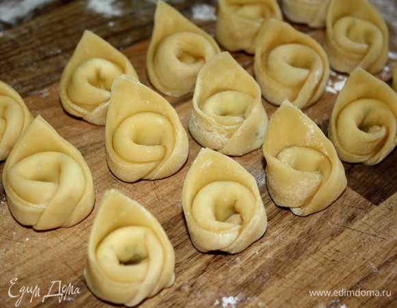 С готовых тортеллини кисточкой стряхнуть излишки муки.