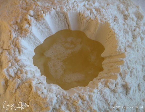 Приготовить тесто. Муку высыпать горкой на рабочую поверхность, слелать углубление и влить растопленное сало.