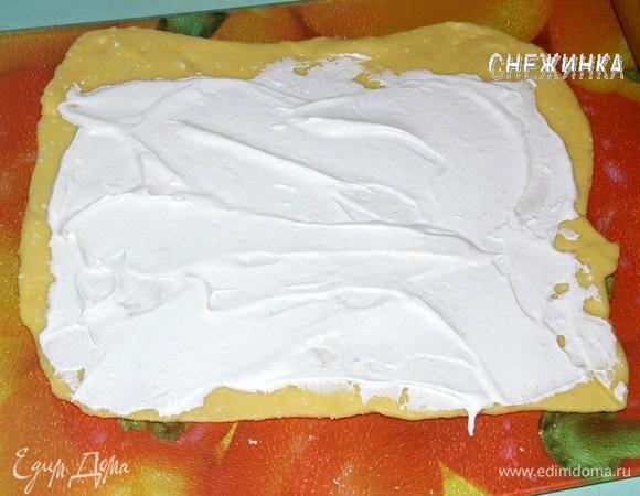 Охлажденное тесто делим на две части. Одну из них раскатываем в прямоугольный пласт достаточно тонко, но чтобы при сворачивании тесто не рвалось. Смазываем половиной меренги, один конец оставив немного пустым. Здесь важно сразу разделить меренгу на две части, чтобы для второй части печенья не оказалось слишком много начинки.