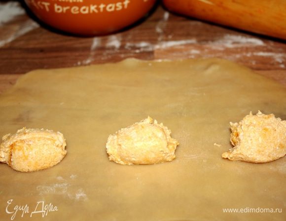 Тесто  разделить на 3-4 части.Каждый кусок раскатать с длинный и тонкий пласт,6-7 см шириной. На середину  выложить порции начинки по 1 полной чайной ложке на расстоянии друг от друга.Тесто вокруг начинки смочить водой.