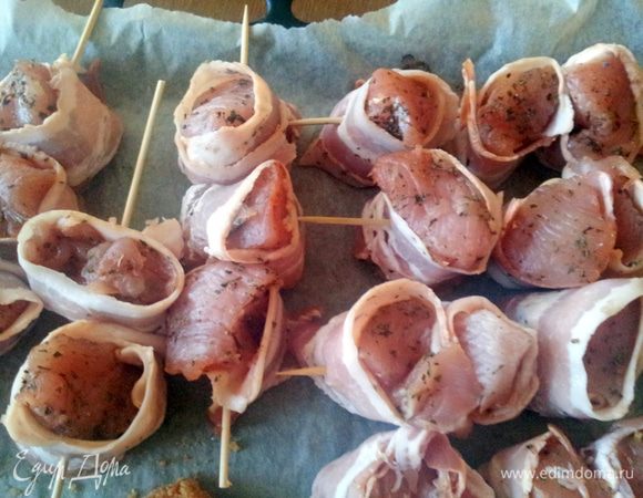 Разогреть гриль или верх у духовки до 200С.
Положить на каждый кусочек индейки листочек базилика, если нет свежего, то посыпать сухим,обернуть каждый кусочек индейки полоской бекона.Надеть шашлычки на шпажки по 3 кусочка на каждую, но так чтобы бекон не развернулся. Когда мясо нанизано, положить шашлычки на застеленный пергаментом притивень и поставить под гриль.

