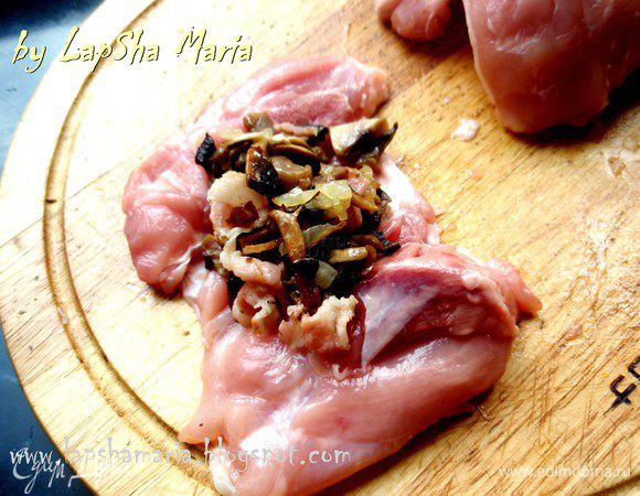 Куриные бедра разрежьте, чтобы получился сплошной пласт, натрите солью и перцем, учтите, что начинка у нас уже соленная, а также присутствует бекон, который отдаст часть соли мясу. Поэтому не переусердствуйте. Немного отбейте каждый кусочек и выложите сверху 1 ст. л. начинки из грибов, бекона и лука.