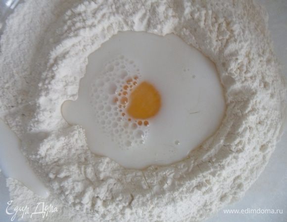 В стакане смешать молоко и воду и влить к яйцу.
