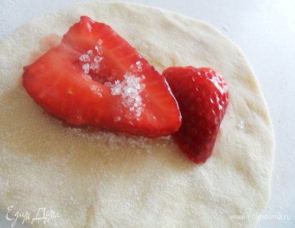 Вырезаем кружочки. Я делала это стаканом. Внутрь насыпаем половину чайной ложки сахара и выкладываем начинку.