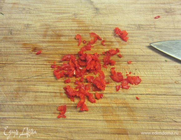Мелко порубите красный перец. Если хотите поострее - используйте вместе с семенами и соединительными перегородками.