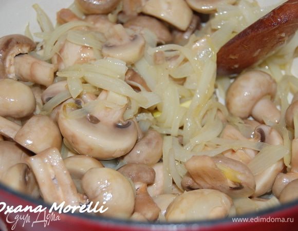 В тяжелой посуде с толстым дном обжарить на растительном масле лук, добавить шампиньоны и чуть позже мясо. Закрыть крышкой и тушить на маленьком огне примерно 30 минут. 